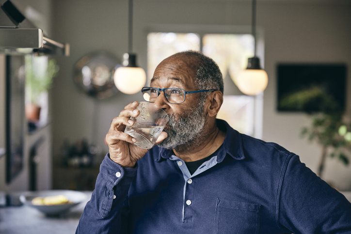 Mann trinkt ein Glas Wasser